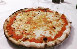 a cheese pizza sitting on top of a table at Acquacheta Valtancoli Hotel B&B in San Benedetto in Alpe