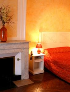 a bedroom with a bed and a fireplace at La Maison Blanche in Romanèche-Thorins