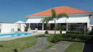 eine Villa mit Swimmingpool und ein Haus in der Unterkunft Maravilhosa Villa com Piscina in Arraial do Cabo