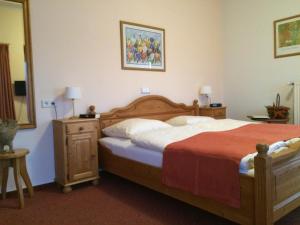 a bedroom with a large bed and a mirror at Landhotel Waldseiter Hof in Bad Bentheim