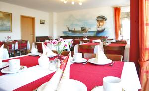 a dining room with a table with white plates and napkins at Hotel zur Brücke in Greifswald