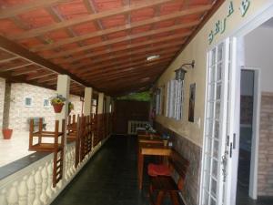 a restaurant with wooden ceilings and wooden tables and chairs at Pousada Tia Lilía in Gonçalves