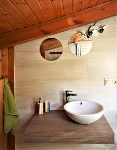 a bathroom with a white sink and wooden ceiling at Valle y Mar, Casa de Huéspedes in La Herradura