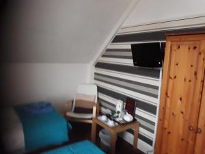 a room with a staircase with a bed and a tv at Glenavon Guest House in Llandudno