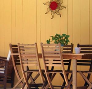 uma mesa de madeira com duas cadeiras e um vaso de plantas em La Maison Blanche em Romanèche-Thorins