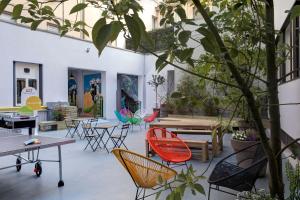 a room with chairs and tables and a tree at The RomeHello in Rome