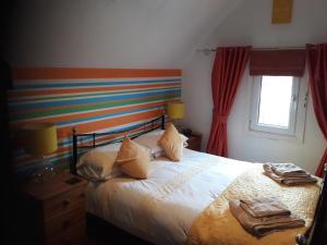 1 dormitorio con 1 cama con toallas en Glenavon Guest House, en Llandudno