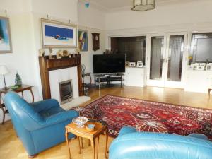 a living room with a blue couch and a fireplace at The Cairn Residence in Edinburgh