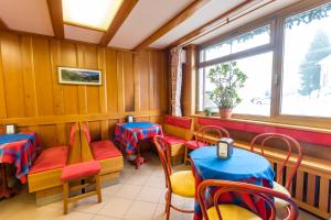 um restaurante com mesas e cadeiras e uma janela em Hotel Punta Cian em Valtournenche