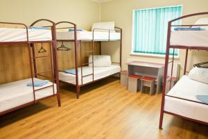 a dorm room with four bunk beds and a wooden floor at Pilgrim Hostel in Ivano-Frankivsk