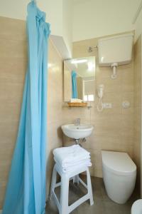 La salle de bains est pourvue d'un lavabo, de toilettes et d'un miroir. dans l'établissement Albergo Anita Alassio, à Alassio
