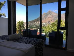 a bedroom with a bed and a view of a mountain at Bayview Boutique Guesthouse in Cape Town