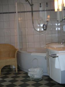 a bathroom with a tub and a toilet and a sink at Landhotel Waldseiter Hof in Bad Bentheim