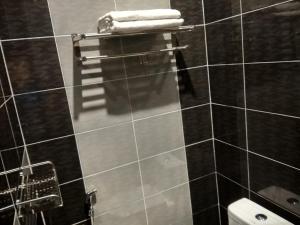 a bathroom with a toilet and towels on a wall at Tehel Farmhouse in Melaka