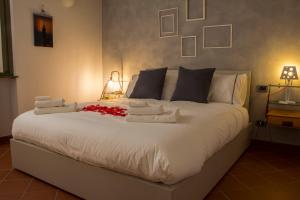 a large bed with white sheets and red flowers on it at Goccia di Lago in Desenzano del Garda