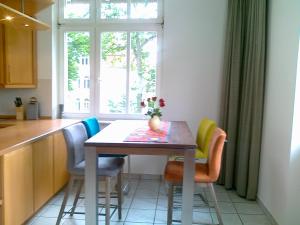 eine Küche mit einem Tisch mit Stühlen und einem Fenster in der Unterkunft Villa Caprivi - 6 in Heringsdorf