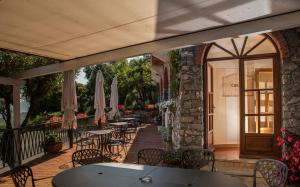 een patio met tafels, stoelen en parasols bij Il Capanno in Pietra Ligure