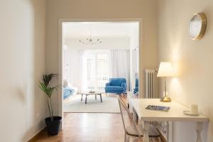 a living room with a table and a blue chair at Chic Flat in the Heart of Athens by UPSTREET in Athens