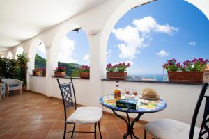 een balkon met een tafel en stoelen en een raam bij Villa Pane Resort in Sorrento