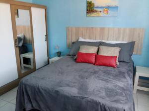 1 dormitorio con 1 cama grande y 2 almohadas rojas en Sol da Cachoeira, en Florianópolis