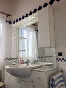 ein Badezimmer mit Waschbecken und Spiegel in der Unterkunft Nicole 2 in Germignaga