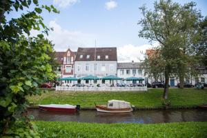 um grupo de barcos na água em frente aos edifícios em Romantik Hotel Aquarium em Friedrichstadt