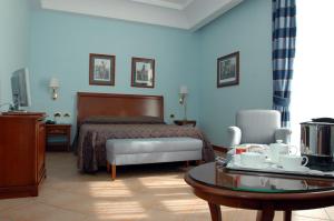 um quarto de hotel com uma cama e uma mesa de centro em Le Cheminée Business Hotel Napoli em Nápoles