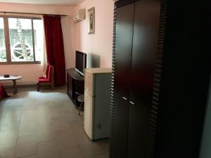 a room with a cabinet and a desk and a television at Annexe de l'Hotel de la Poste in Antsiranana