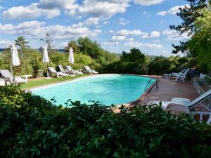 a swimming pool with chairs and umbrellas at Due Piani in Barberino di Val dʼElsa