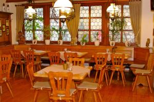 ein Esszimmer mit Tischen, Stühlen und Fenstern in der Unterkunft Gasthof zum Kauzen in Ochsenfurt