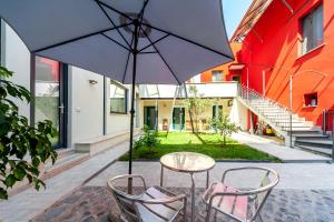 a table and chairs with an umbrella in a courtyard at Il Giardino Dell'Argano Rosso in Rome