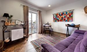 a living room with a purple couch and a table at Peacock House in Évora