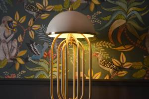 a lamp in front of a wall with a painting at Linnen Luxx Apartment in Berlin