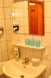 a bathroom with a sink and a mirror at Gasthof zum Kauzen in Ochsenfurt