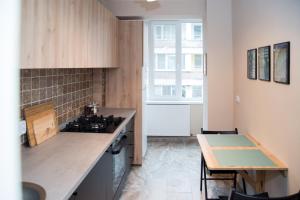 a kitchen with a stove and a table and a window at Ultracentral, brand new, modern and cozy apartment in Timişoara