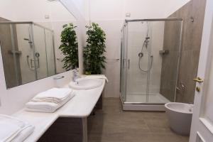 a bathroom with a sink and a shower with plants at Savoy Riviera in Naples +33 photos