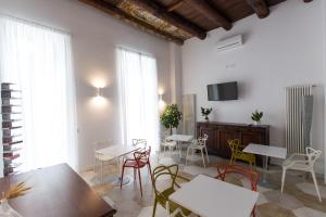 a living room with tables and chairs and a tv at Savoy Riviera in Naples