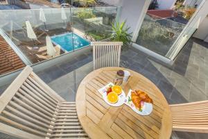 a table with breakfast food on it on a balcony at Apartmani Pocco Locco in Biograd na Moru