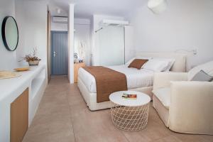 a white bedroom with a bed and a couch at Alunia Incognito Suites - Adults Only in Pyrgos