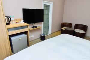 um quarto com uma cama e uma televisão de ecrã plano em Fu Yu Spring House em Baihe