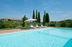 a swimming pool with chairs and an umbrella at Villa Lorian in Argiano