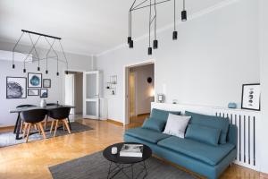 a living room with a blue couch and a table at Acropolis Core Bright & Modern Apartment by UPSTREET in Athens