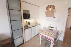 eine Küche und ein Esszimmer mit einem Tisch und Stühlen in der Unterkunft Studio Olympe in Juan-les-Pins