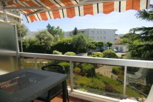 einen Balkon mit einem Tisch und Parkblick in der Unterkunft Studio Olympe in Juan-les-Pins