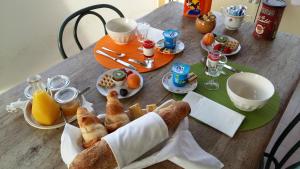 - une table en bois avec des aliments pour le petit-déjeuner et des boissons dans l'établissement La Belle Etape, à Lamonzie-Saint-Martin