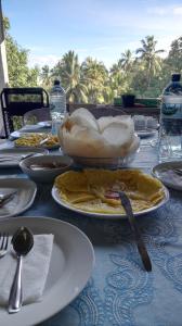 einen Tisch mit Teller mit Lebensmitteln darüber in der Unterkunft K Holiday in Tissamaharama