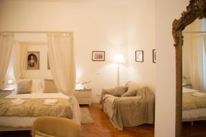 1 dormitorio con 2 camas, sofá y espejo en St Paul House Boutique & Apartment, en Roma