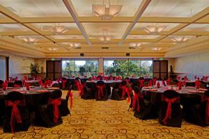 a banquet hall with tables with red bows on them at Win-River Resort and Casino in Redding +37 photos