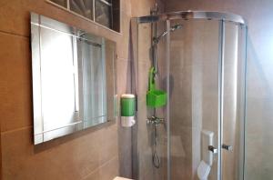a shower in a bathroom with a glass door at 1977 in Faro