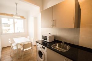 a kitchen with a sink and a microwave and a table at 1977 in Faro
